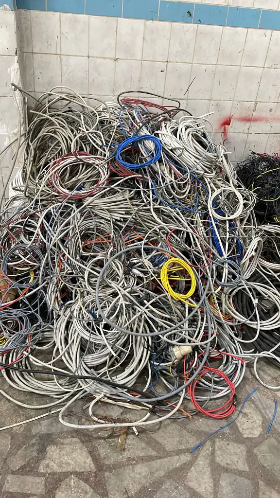 Bina tesisatından sökülmüş gri, beyaz, mavi ve kırmızı ince kesitli NYM tesisat kablolarından oluşan hurda yığını